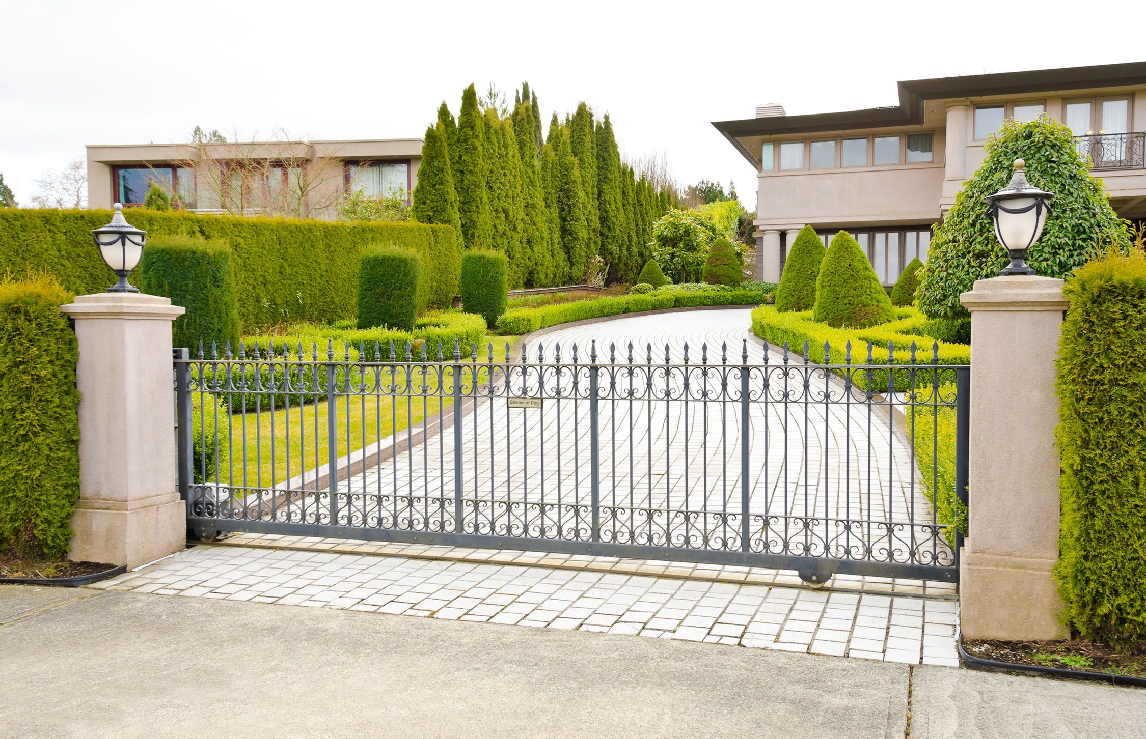 gated entry in southern us with a modern home and greenery